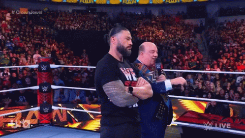 Two Wrestlers Are Standing In A Wrestling Ring And One Has A Shirt That Says Life Is Me GIF