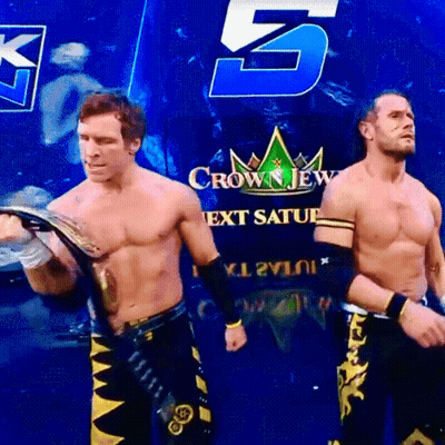two wrestlers are standing in front of a crown jew next saturday sign