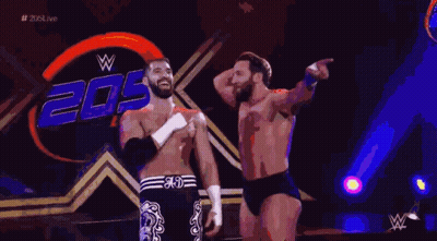 Two Wrestlers Are Standing In Front Of A Sign That Says 20 GIF
