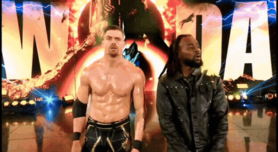 Two Wrestlers Are Standing In Front Of A Sign That Says Wwe GIF