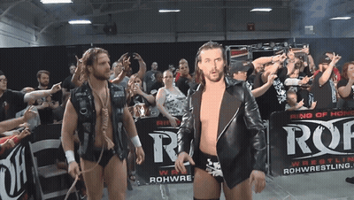 Two Wrestlers Are Walking In Front Of A Sign That Says Ring Of Honor GIF