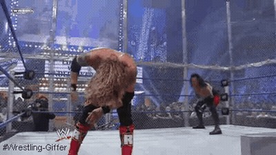 Two Wrestlers Are Wrestling In A Ring With A Fence In The Background . GIF
