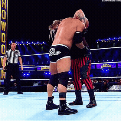 Two Wrestlers Are Wrestling In A Ring With A Sign That Says Super Showdown GIF