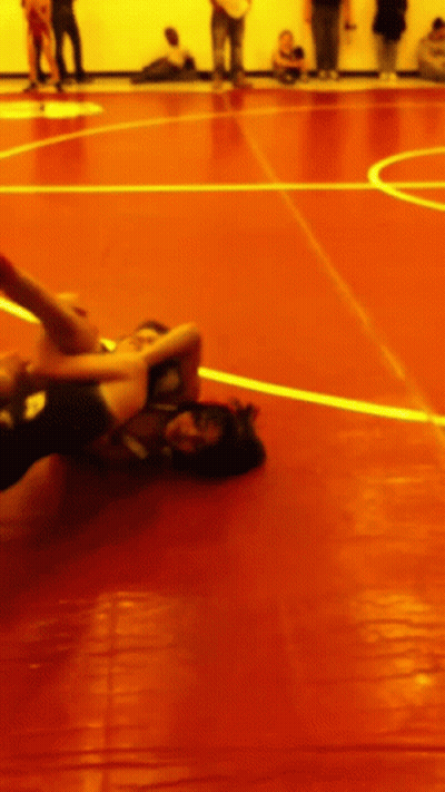 Two Wrestlers Are Wrestling On A Red Mat With A Yellow Line GIF