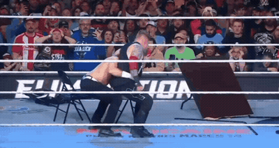 Two Wrestlers Fighting In Ring With Table GIF