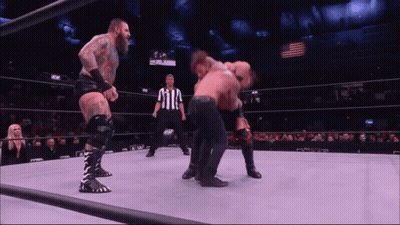 Two Wrestlers Fighting In Wrestling Ring With Referee GIF