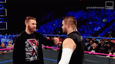 Two Wrestlers Hugging In Wrestling Ring GIF