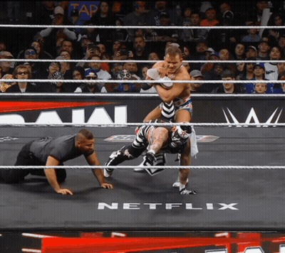 Two Wrestlers In A Ring With A Netflix Logo In The Background GIF