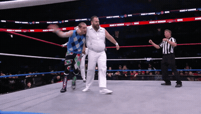 Two Wrestlers In A Ring With The Words King Of Honor On The Walls GIF