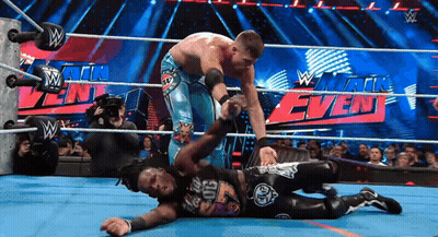 Two Wrestlers In A Wrestling Ring With A Sign That Says W GIF