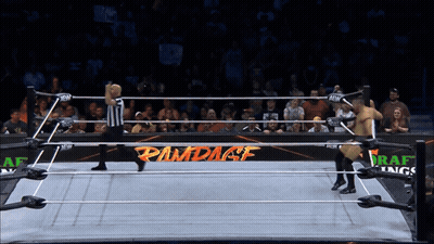 Two Wrestlers In Ring With Rampage Sign GIF