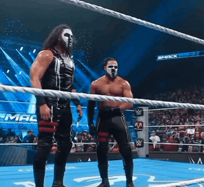 Two Wrestlers In Ring With Smack Down Sign GIF