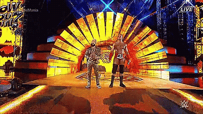 Two Wrestlers On Stage In Front Of Sun GIF