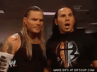 Two Wrestlers Standing In Dark Room Looking At Each Other GIF