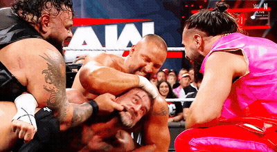 Two Wrestlers Standing In Front Of WWE Sign GIF