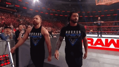 Two Wrestlers Wearing Hounds Of Justice T-Shirts Walk Out Of The Ring GIF