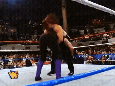Two Wrestlers Wrestling In Ring With W Logo GIF
