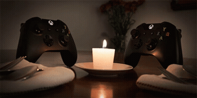 Two Xbox Controllers Next To Lit Candle GIF