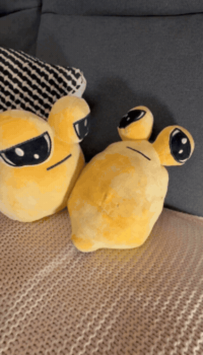 Two Yellow Stuffed Animals Are Sitting On A Bed Next To A Pillow GIF