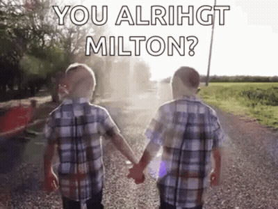 Two Young Boys Are Holding Hands On A Gravel Road . GIF