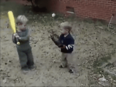Two Young Boys Are Playing Baseball In The Dirt And One Is Holding A Bat GIF
