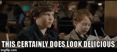 Two Young Boys Are Sitting At A Table In A Restaurant And Eating . GIF
