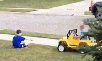 Two Young Boys Are Sitting On The Grass Next To A Yellow Toy Car . GIF
