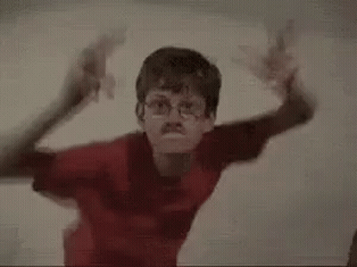 Two Young Boys Are Standing Next To Each Other In A Room . GIF