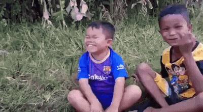 Two Young Boys Sitting On Grass GIF