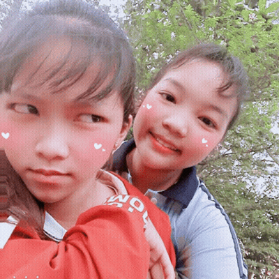 Two Young Girls Are Posing For A Picture With One Wearing A Shirt That Says " Seoul " GIF