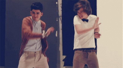 Two Young Men Are Dancing Together In Front Of A Door . GIF