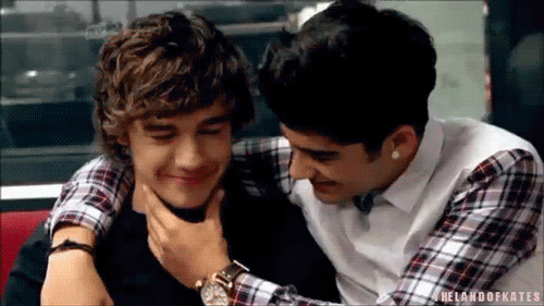 Two Young Men Are Hugging Each Other In A Restaurant And One Of Them Is Holding The Other 'S Neck . GIF