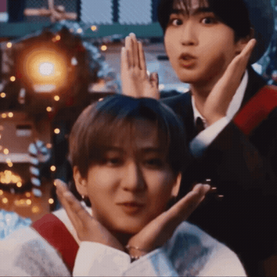 Two Young Men Are Making Funny Faces With Their Hands Over Their Faces GIF