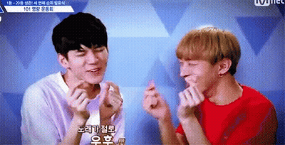 Two Young Men Are Making Heart Shaped Fingers With Their Hands . GIF