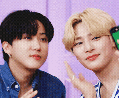 Two Young Men Are Posing For A Picture And One Is Holding A Cell Phone GIF