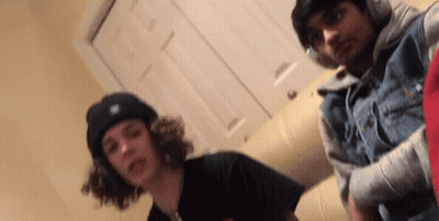 Two Young Men Are Posing For A Picture Together In A Room . GIF