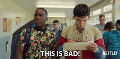 Two Young Men Are Standing In A Hallway And One Of Them Is Holding A Piece Of Paper That Says This Is Bad On It GIF