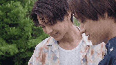 Two Young Men Are Standing Next To Each Other And One Is Smiling GIF