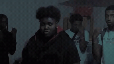 Two Young Men Are Standing Next To Each Other In Front Of A Blue Sky . GIF