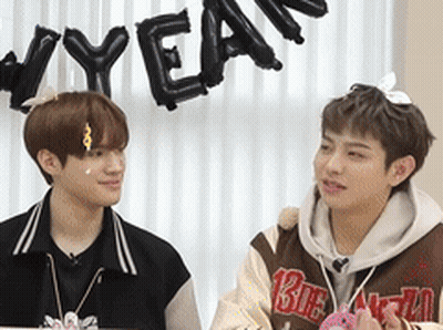 Two Young Men Beside New Year Sign GIF