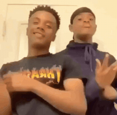Two Young Men Dancing Next To Each Other GIF