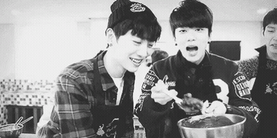Two Young Men Eating In Kitchen GIF