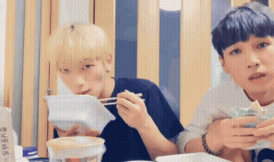 Two Young Men Eating With Chopsticks GIF