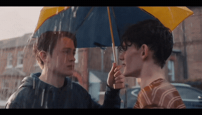 Two Young Men Holding Umbrella In Rain GIF