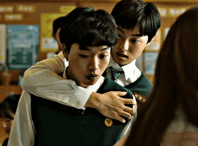 Two Young Men Hugging In Classroom GIF