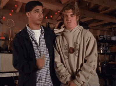 Two Young Men In Garage, One In Hoodie GIF