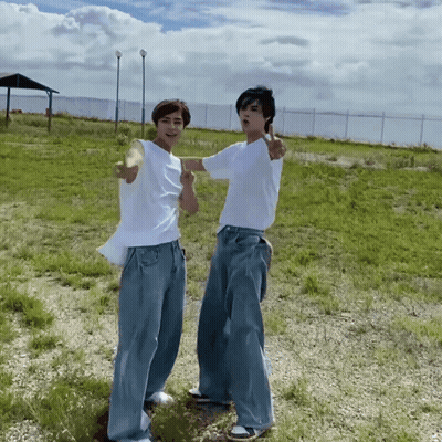 Two Young Men In Grassy Field GIF