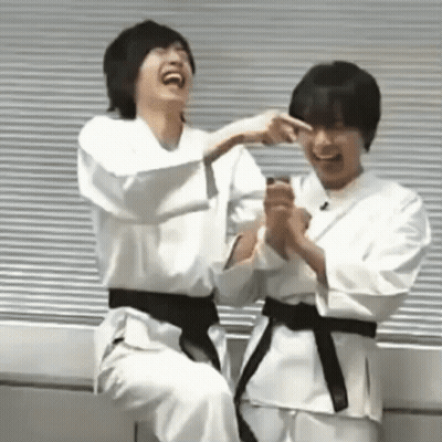 Two Young Men In Karate Uniforms Laughing Together GIF