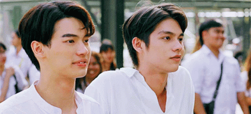 Two Young Men In White Shirts Are Standing Next To Each Other . GIF