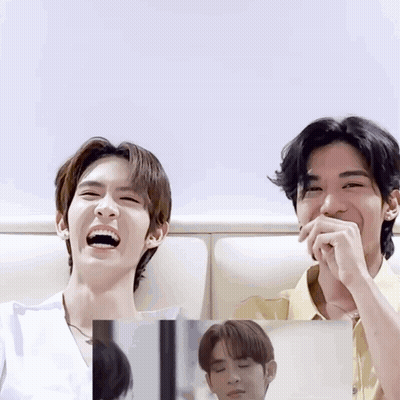 Two Young Men Laughing With Mouths Closed